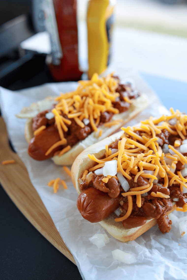 Hot dogs cooking on a Blackstone flat top grill with golden seared edges and grill marks.