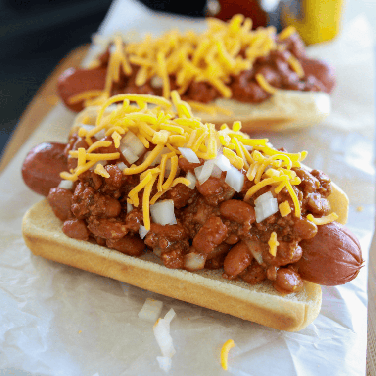 Hot dogs sizzling on a Blackstone flat top griddle with crispy browned edges and grill sear marks.