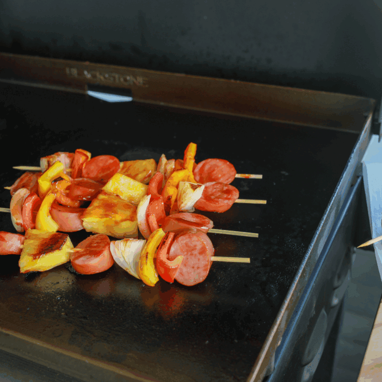 Kielbasa sausage sliced into rounds on a cutting board for the Blackstone griddle