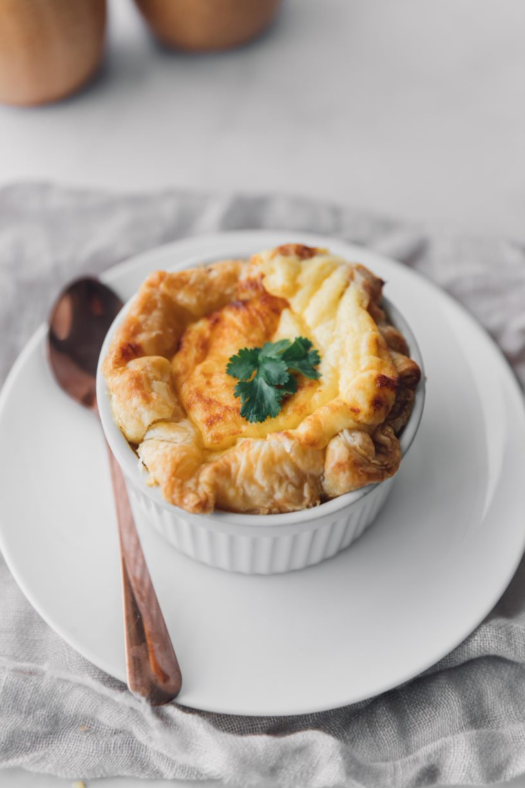 Copycat Panera four cheese soufflé on a white plate, golden brown with a flaky puff pastry crust