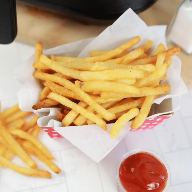 Golden crispy frozen French fries freshly cooked on a Blackstone flat top griddle.