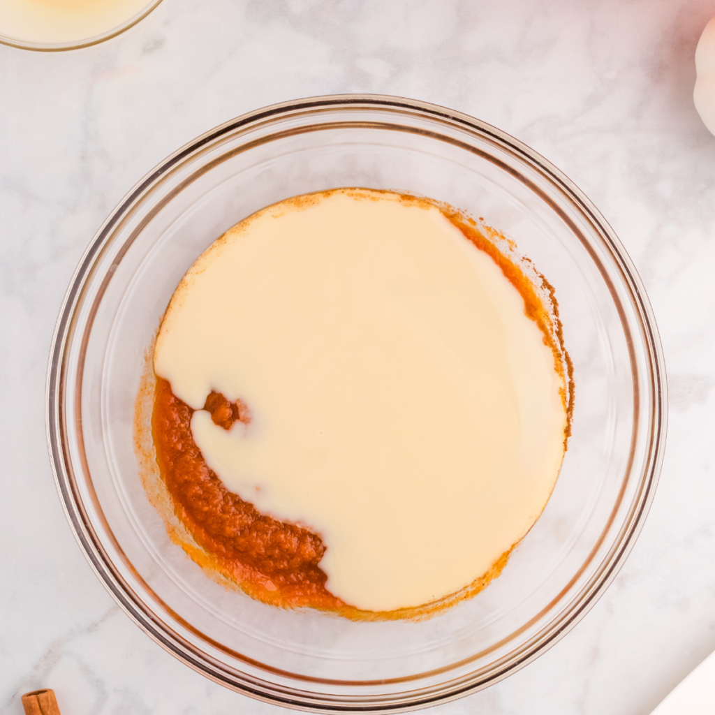 Pumpkin ice cream base whisked together in a mixing bowl before freezing