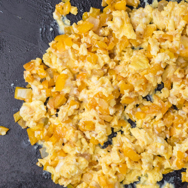 Infrared thermometer showing low heat on a Blackstone griddle for scrambled eggs
