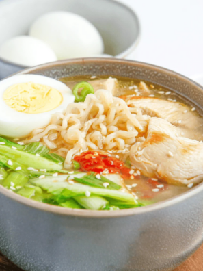 slow cooker chicken ramen in a dark bowl with jammy egg, nori and scallions