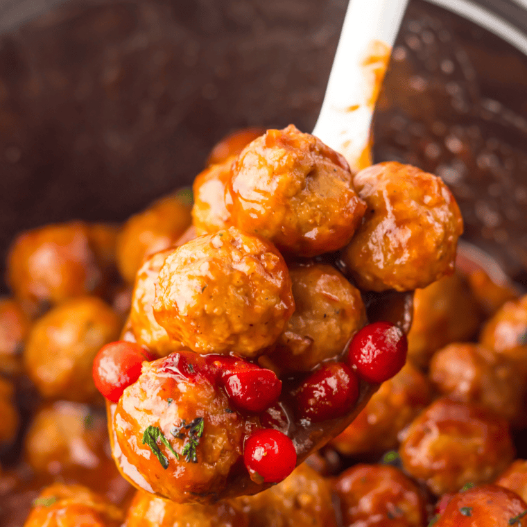 Slow cooker turkey meatballs served over spaghetti with parmesan and basil