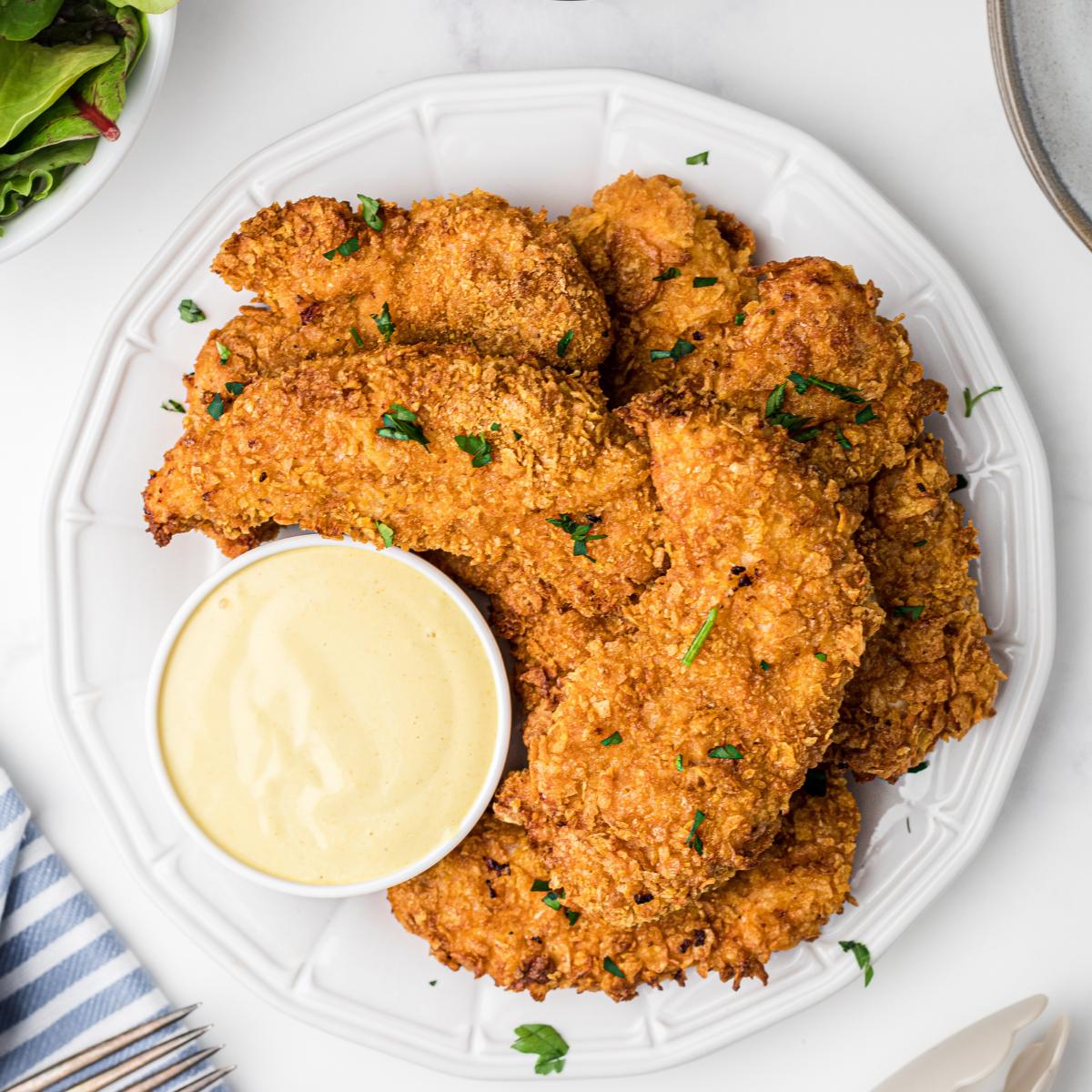 Serving Zaxby’s chicken fingers with dipping sauce and fries.