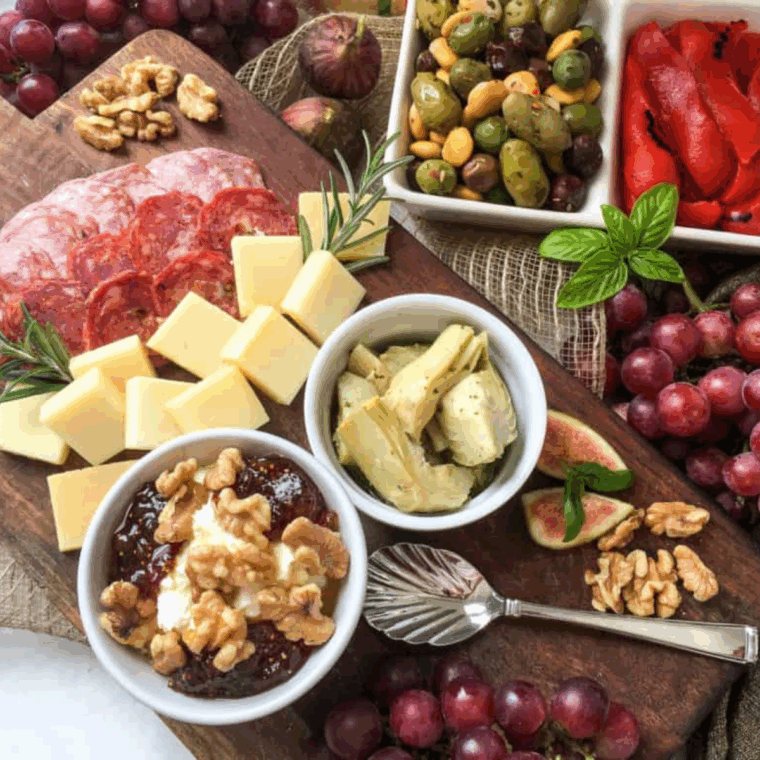 Air fryer appetizer charcuterie board featuring crispy bites, assorted cheeses, cured meats, fresh fruits, and small bowls of dips arranged on a serving platter.