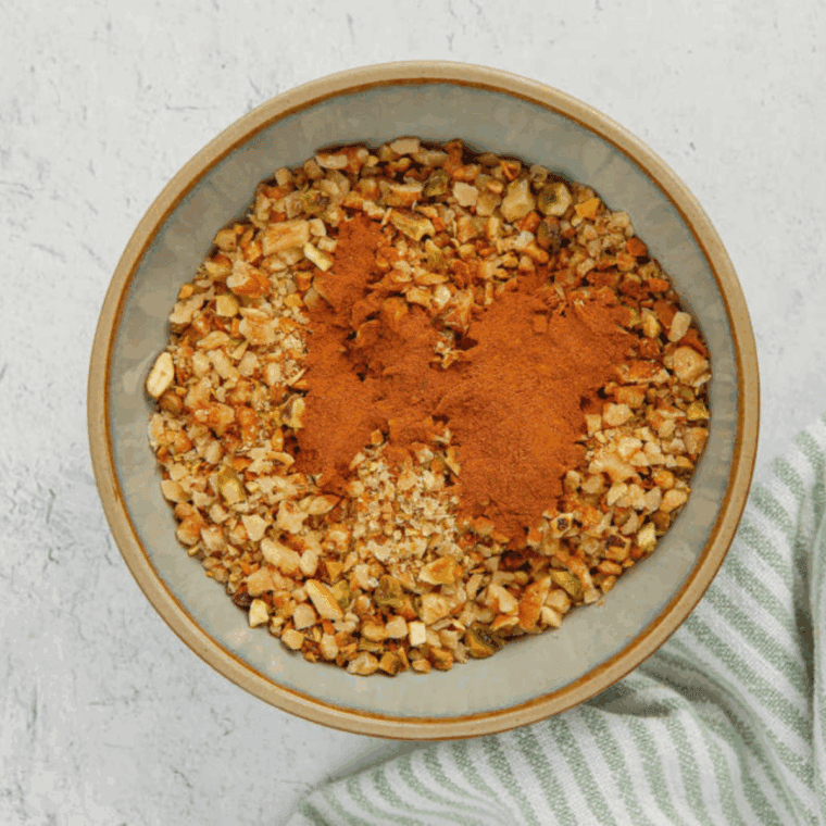Mixing chopped nuts and cinnamon in a bowl.