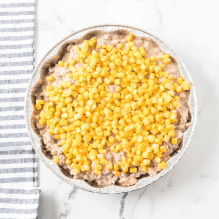 Sour cream and tomato sauce stirred into cooked ground beef in a skillet