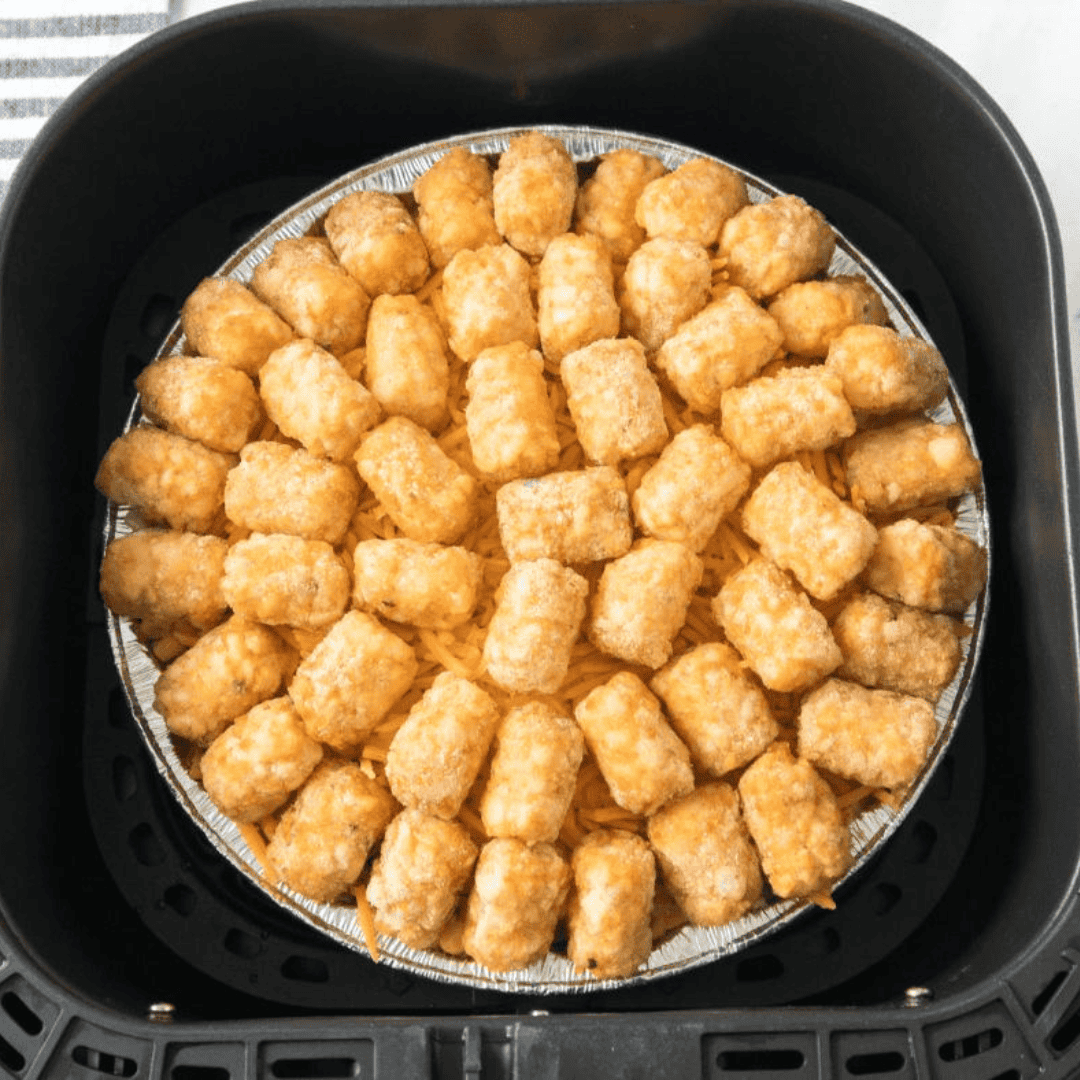 Shredded cheddar and corn layered over seasoned beef in an air-fryer baking dish