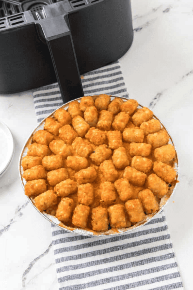 Close-up of crispy tater tots on top of bubbly air fryer cowboy casserole