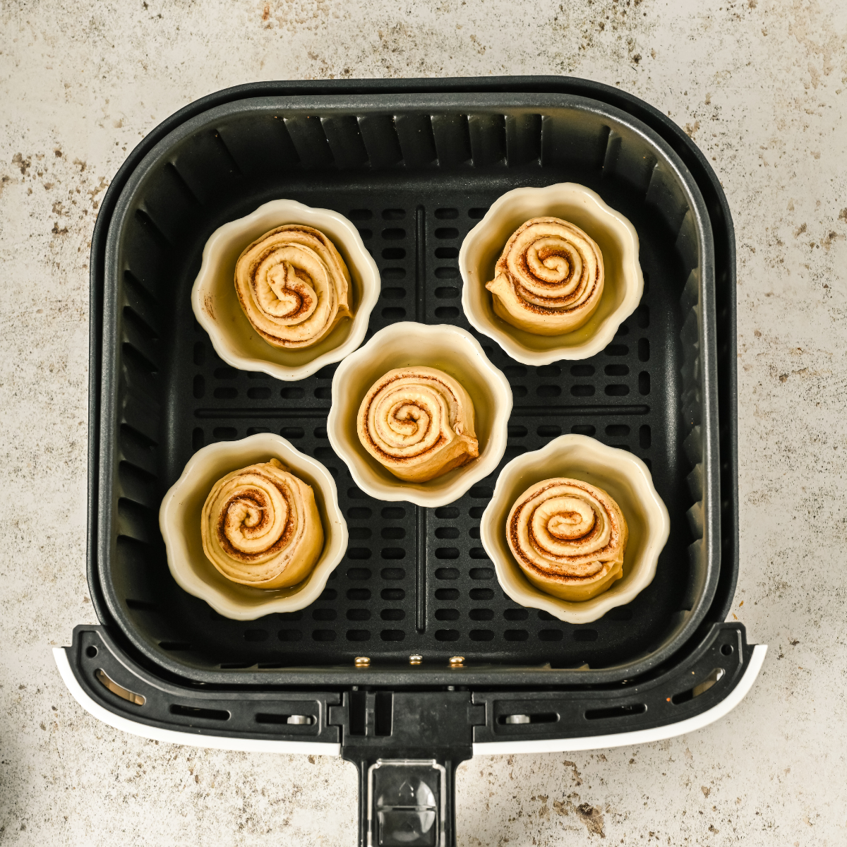 Cruffins cooking in the Air Fryer: Air Fryer basket with Cruffins baking inside, golden and flaky.