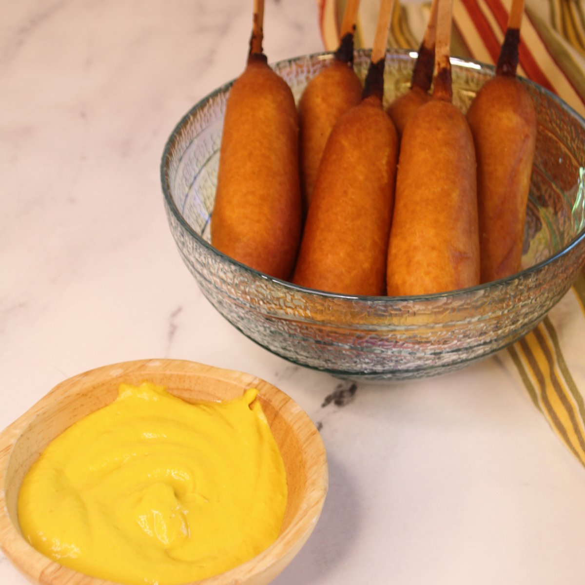 Here are some pro tips for cooking corn dogs in an air fryer:
Preheat the air fryer: Preheating the air fryer is important to ensure that it reaches the desired cooking temperature, resulting in even and consistent cooking of the corn dogs.
Do not overcrowd the basket: It's important to arrange the corn dogs in a single layer in the air fryer basket, leaving space between them. This allows hot air to circulate around each corn dog, resulting in better browning and crispiness.
Lightly grease the basket: To prevent the corn dogs from sticking to the air fryer basket, lightly coat it with non-stick cooking spray or brush it with a thin layer of oil. This helps ensure easy removal of the corn dogs after cooking.
Flip halfway through cooking: To achieve even browning and crispiness, flip the corn dogs halfway through the cooking time. This helps to evenly cook both sides and prevent any one side from becoming too dark.
Adjust cooking time if needed: Cooking times may vary depending on the size, thickness, and brand of the corn dogs, as well as the specific model of your air fryer. Keep an eye on the corn dogs as they cook and adjust the cooking time if needed to achieve your desired level of crispiness.
Check the internal temperature: To ensure that the corn dogs are fully cooked, use a meat thermometer to check their internal temperature. The temperature should reach 165°F (74°C) for safe consumption.
Let them rest before serving: After cooking, allow the corn dogs to rest for a few minutes before serving. This helps to retain their juiciness and allows them to cool slightly for safer handling.
Serve with condiments: Corn dogs are often enjoyed with various condiments such as ketchup, mustard, or cheese sauce. Serve them with your favorite condiments to enhance their flavor and enjoy the full experience.
By following these pro tips, you'll be able to achieve perfectly cooked corn dogs with a crispy exterior and a tender inside using your air fryer. Enjoy them as a delicious snack or as part of a meal.