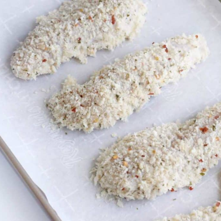 Placing chicken tenders in the air fryer basket, ensuring they are evenly spaced for crispiness.