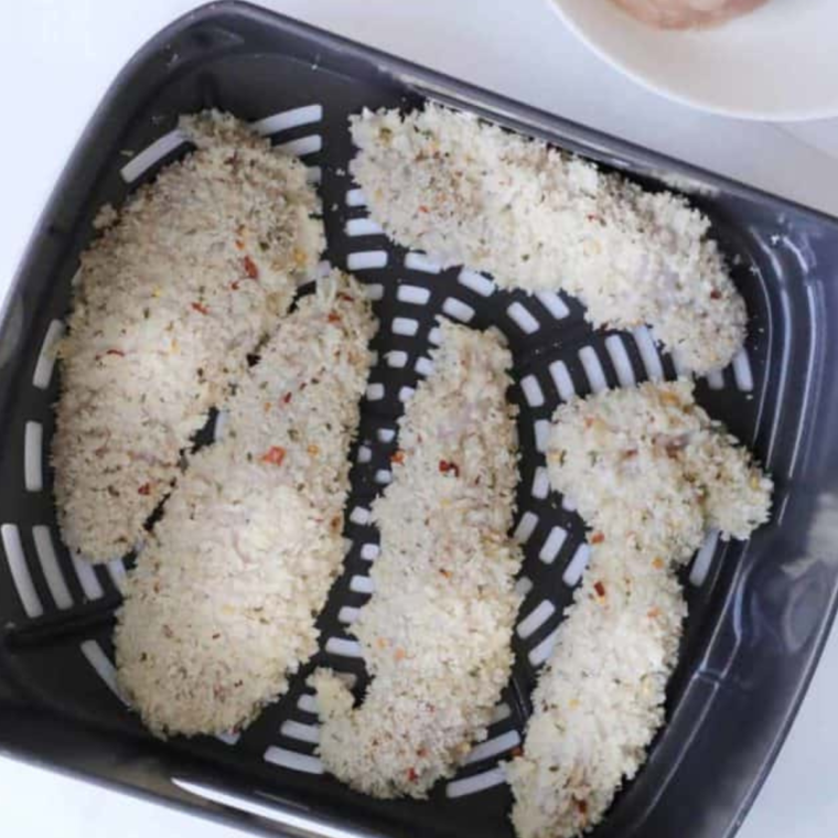 Air frying chicken tenders until golden brown and crispy, showing the cooking process.