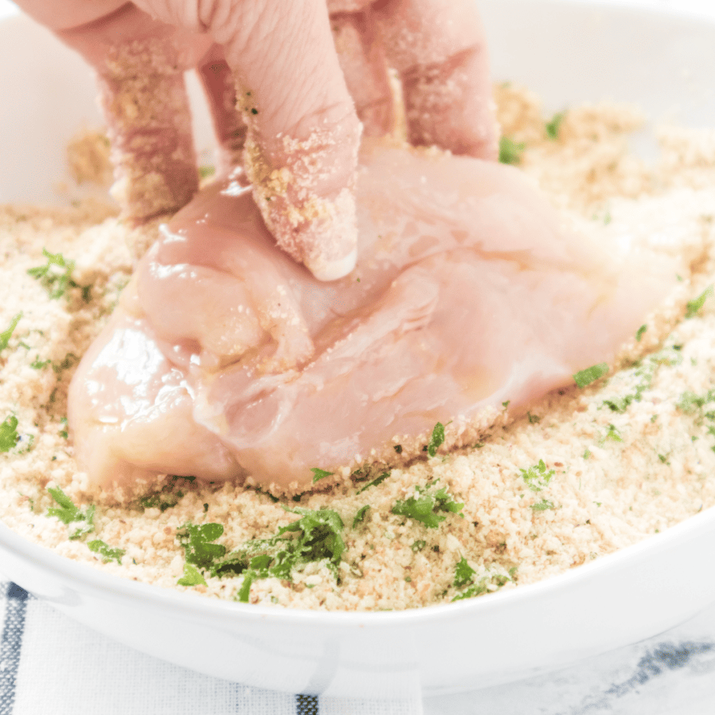 Chicken breasts in a zip-top bag being marinated with Italian dressing, garlic powder, onion powder, salt, and pepper, ready for refrigeration.
