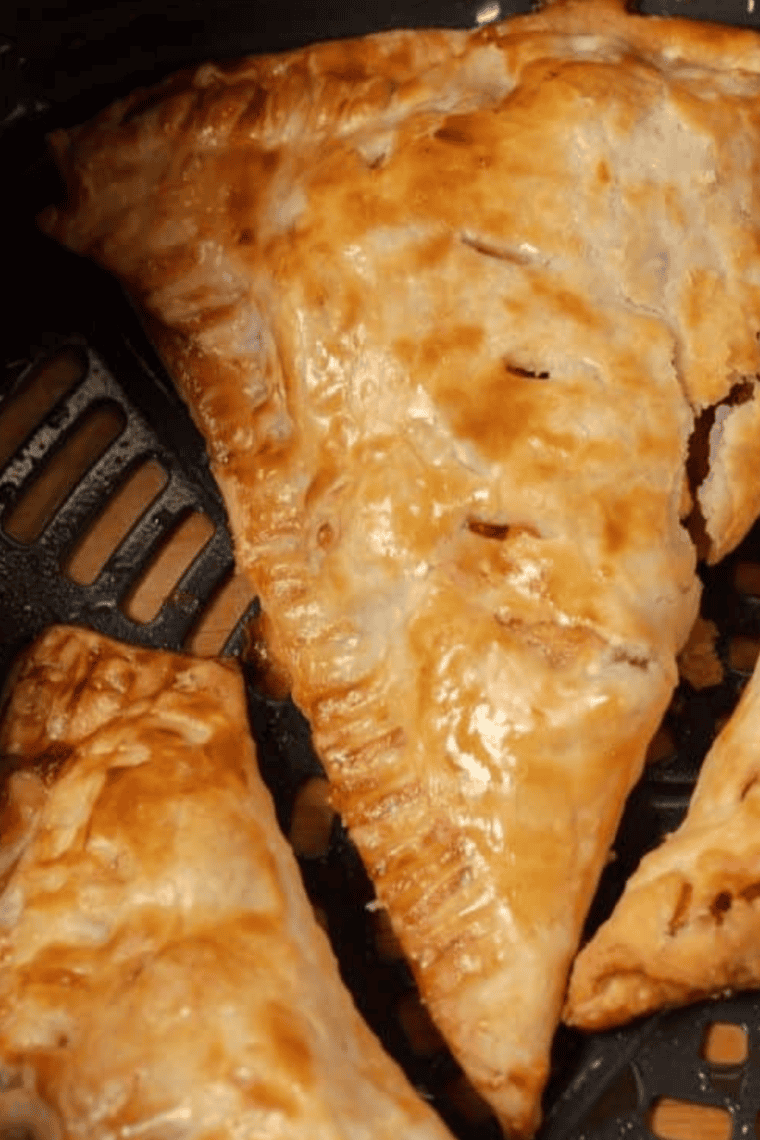 Golden, crispy air fryer peach pie with flaky crust and sweet peach filling on a plate.