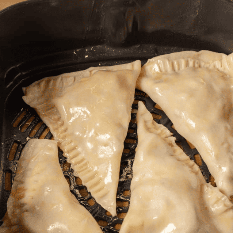 Egg wash brushed on top of pies, placed in air fryer basket, and sprinkled with raw turbinado sugar after cooking.