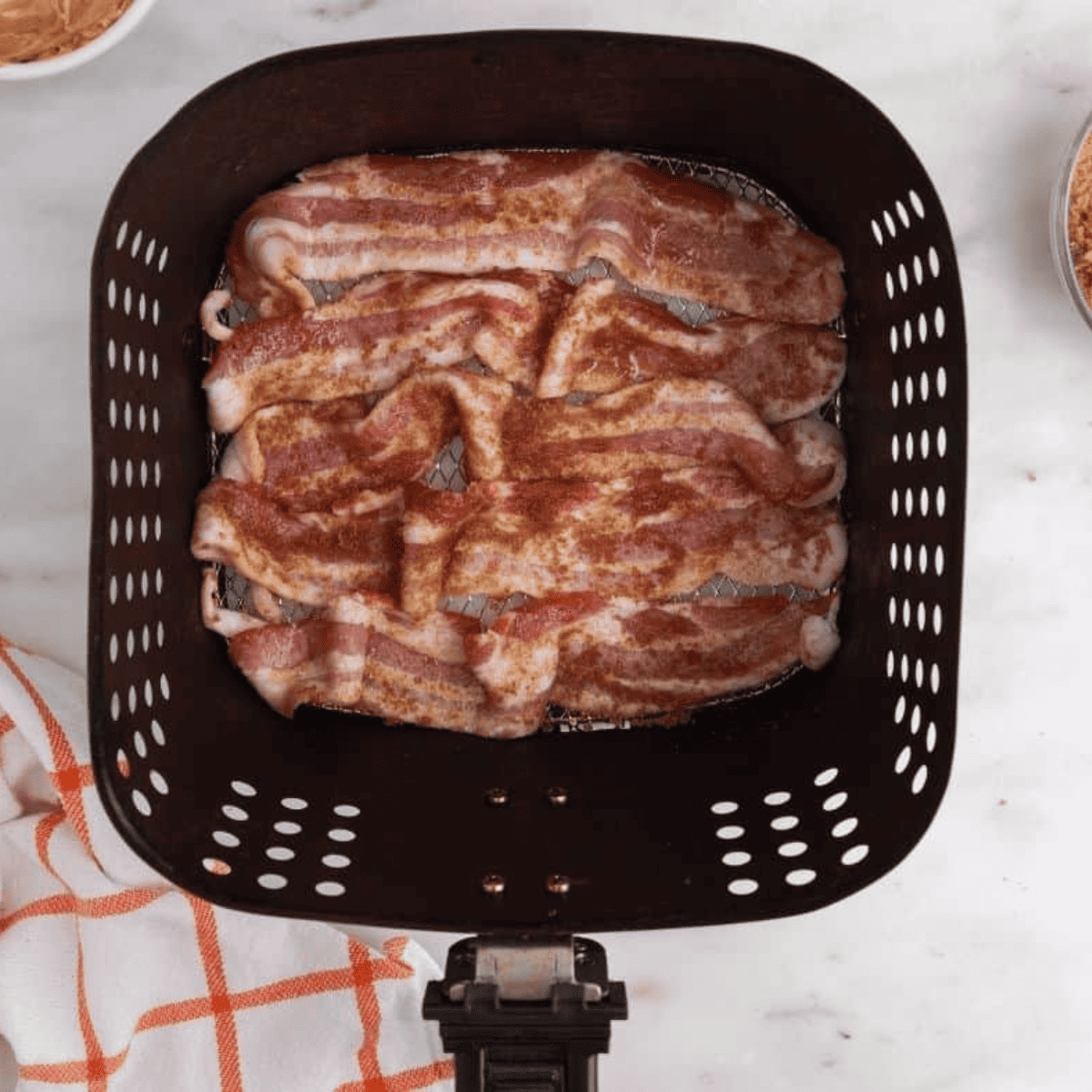 Place bacon strips in the air fryer basket, sprinkle with brown sugar mixture, rub in, and cook for 5 minutes; flip and cook for an additional 4-5 minutes until caramelized.