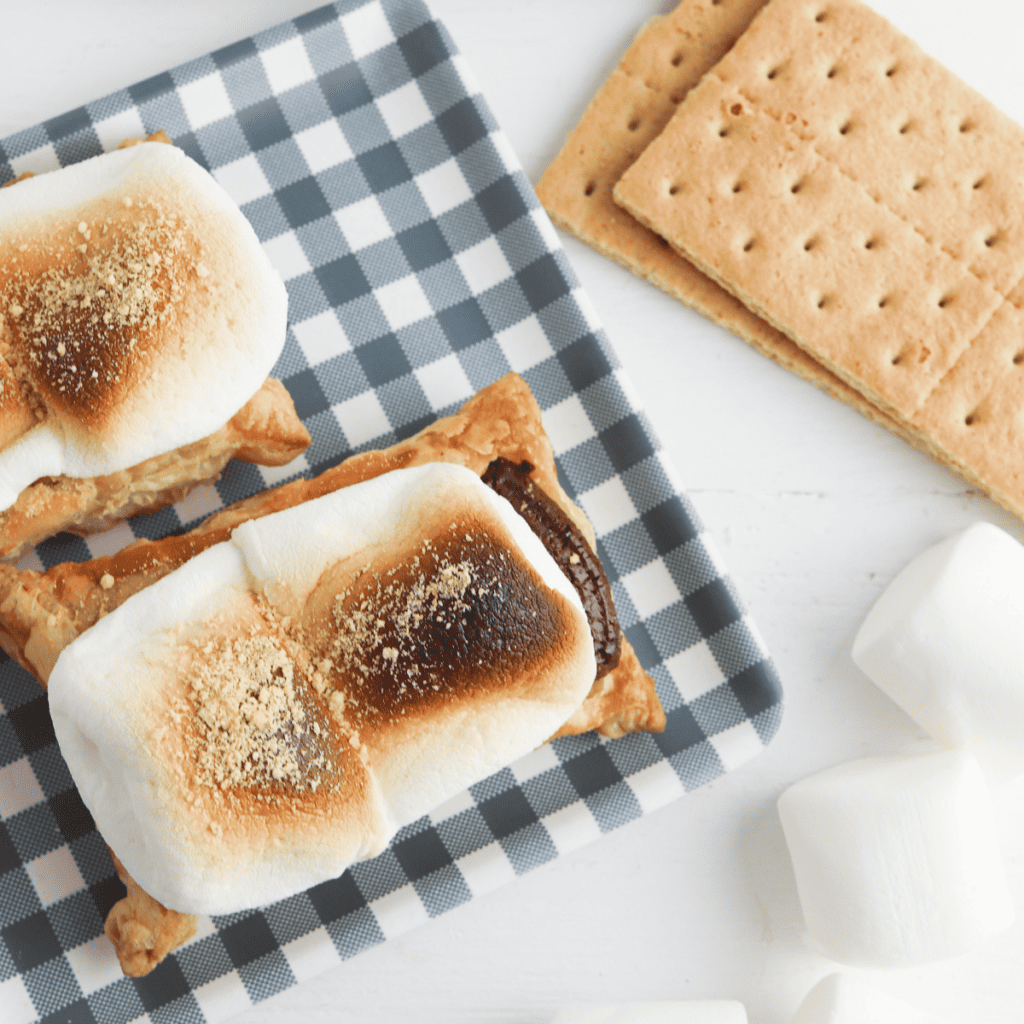 Air-fried puff pastry bites filled with melted chocolate and toasted marshmallows, stacked on a plate and ready to serve.