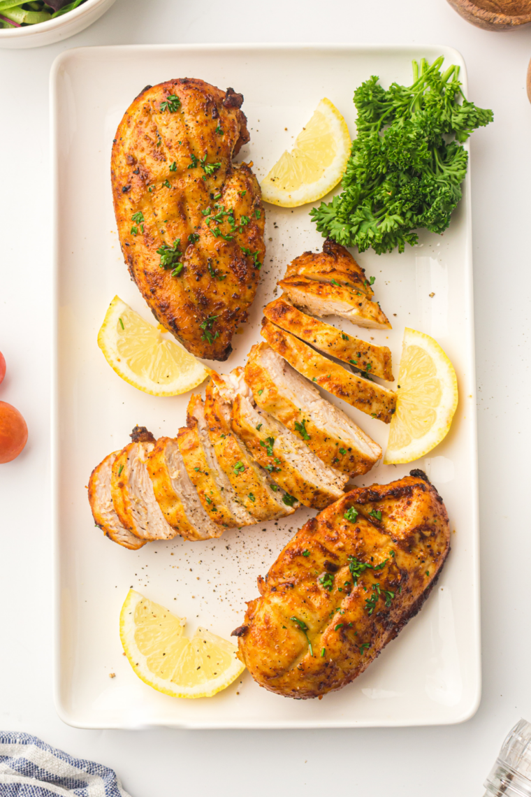 Air fryer rosemary chicken breast cooked juicy with golden herb crust on a white plate