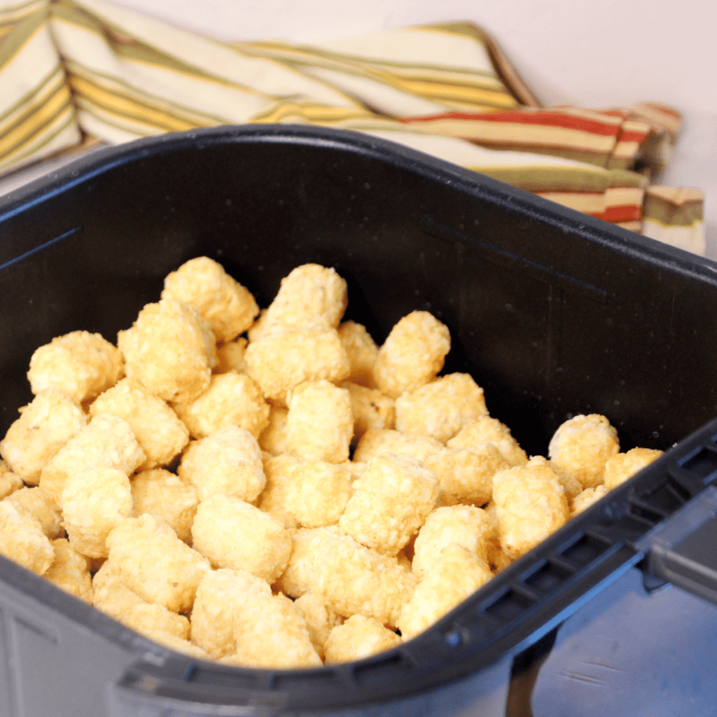 An air fryer preheating to 400°F (200°C) with a timer showing 5 minutes.