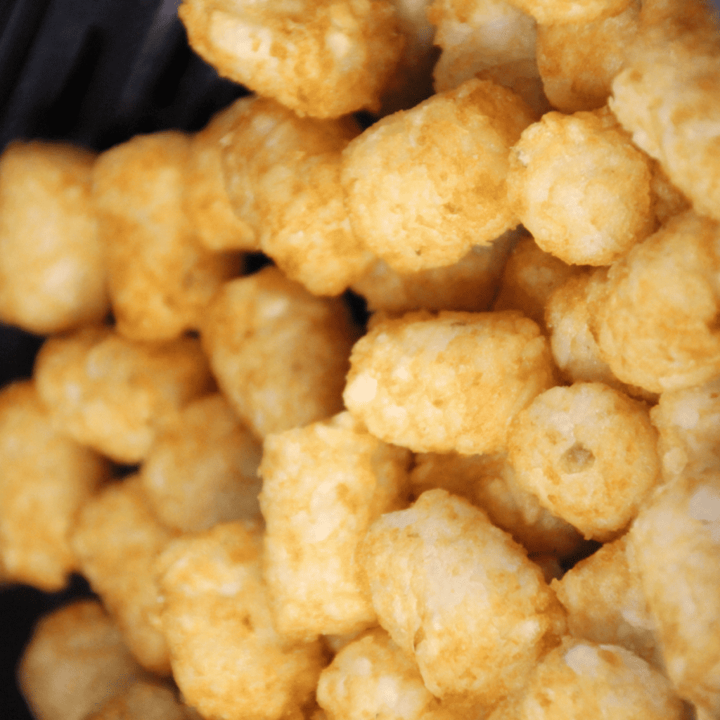 Golden and crispy Sonic Tater Tots cooked in the air fryer, served hot and ready to enjoy with dipping sauce.