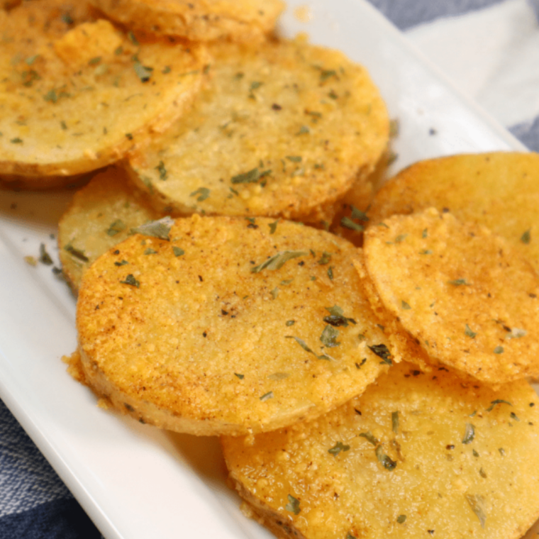 Air fryer Parmesan crusted potatoes with a golden cheese layer and parsley garnish