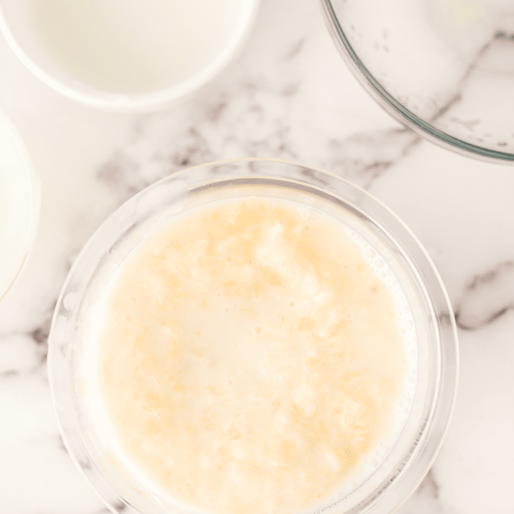 Mixing ingredients in a Ninja Creami pint container and placing it in the freezer with the lid secured.
