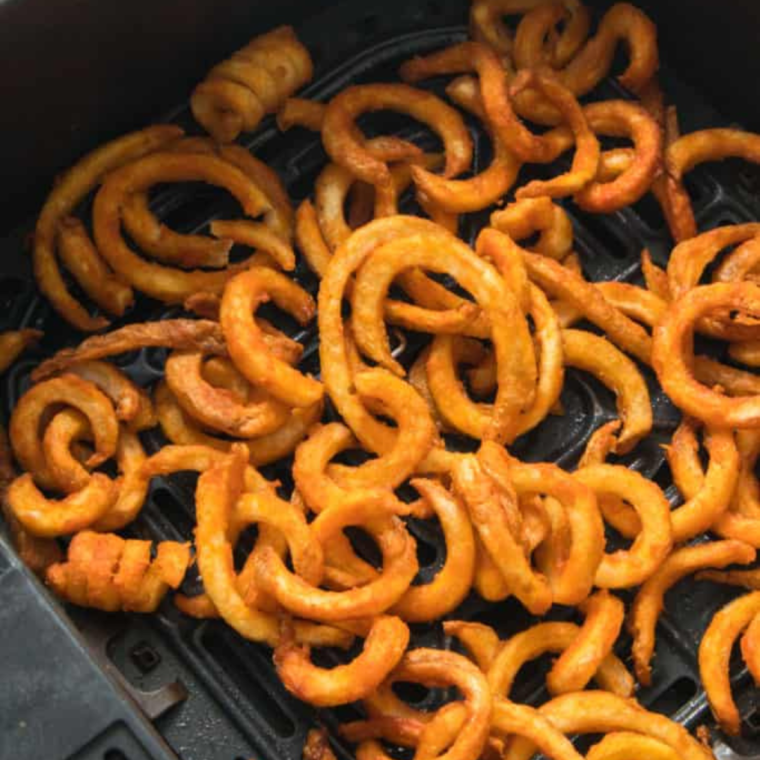 Place frozen curly fries into the air fryer basket.