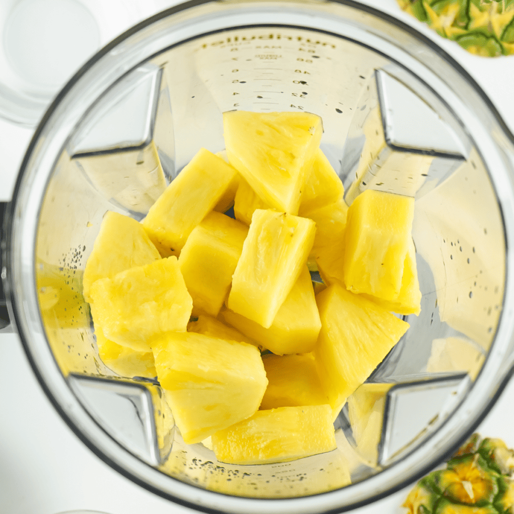 Pineapple chunks and juice added to Ninja Creami pint container up to the max fill line