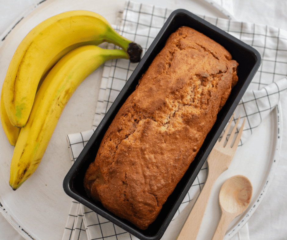 overhead: a bunch of bananas next to banana bread in a loaf pan