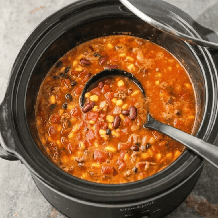 Cooked chicken and vegetables in enchilada broth after slow cooking.
