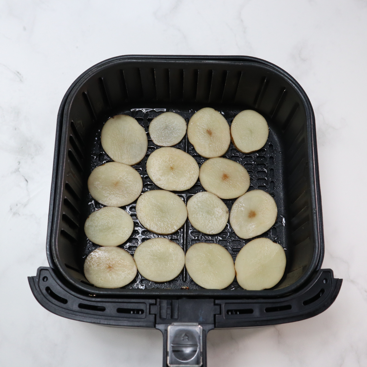 Place sliced potatoes in the air fryer basket.