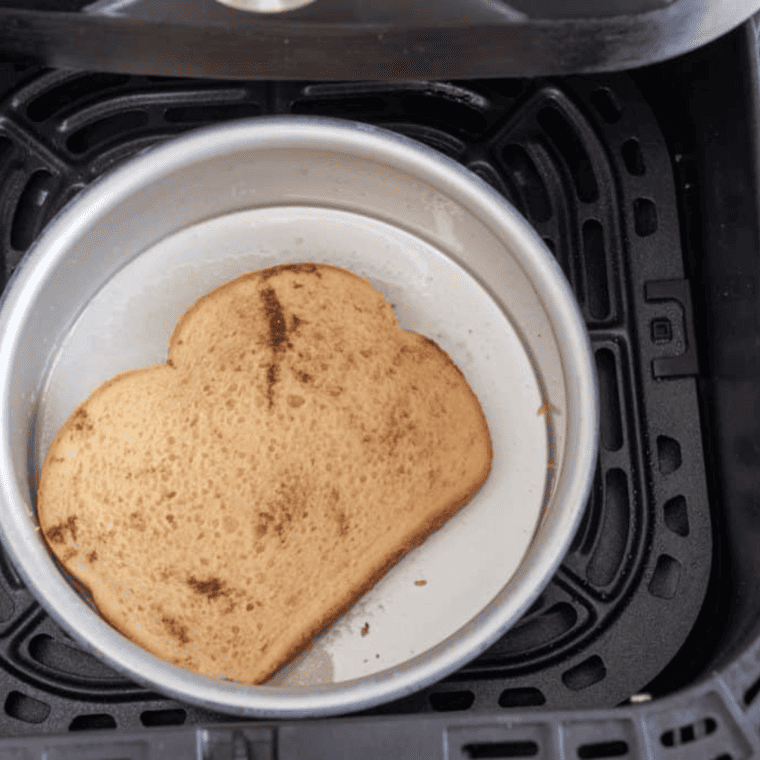 Cook the French Toast: Soaked bread slices arranged in a single layer in the air fryer basket, cooking until golden brown and crispy.