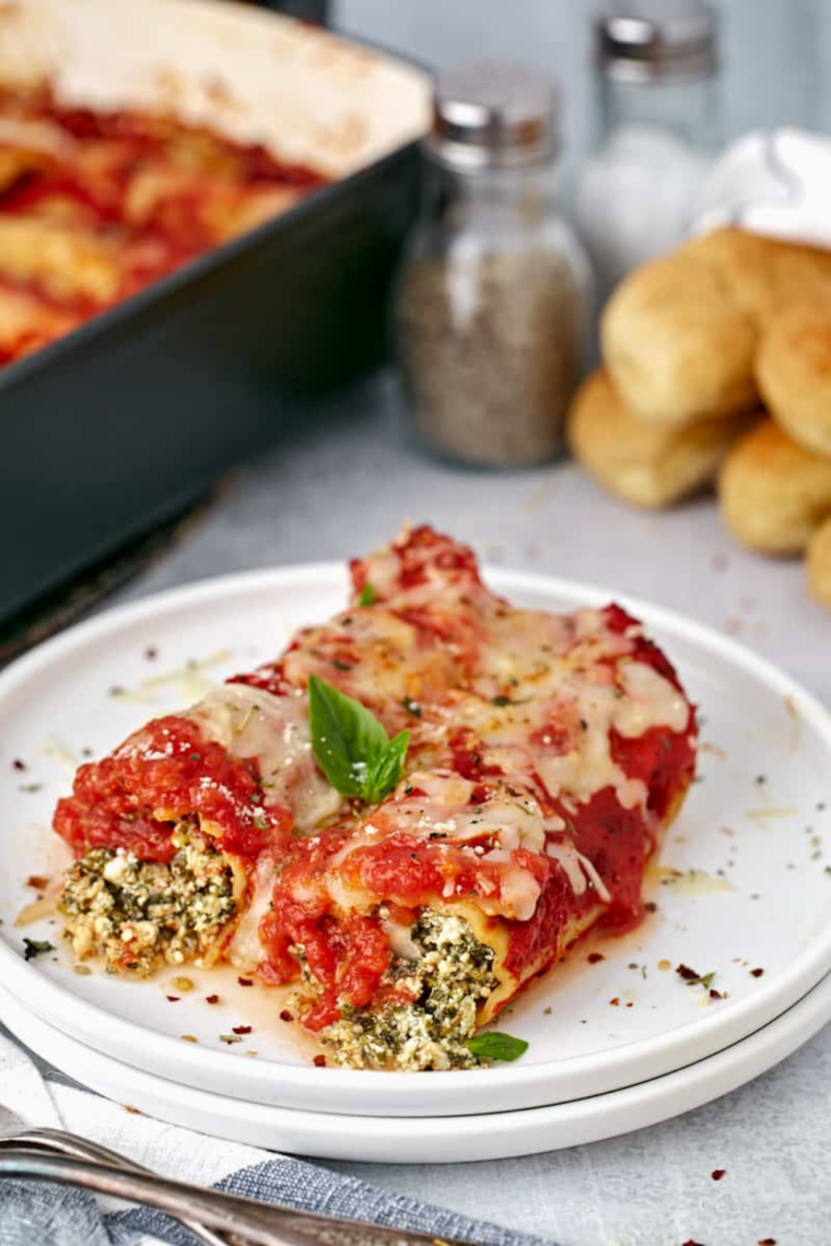 Plate of golden, cheesy air fryer manicotti topped with marinara sauce and melted mozzarella