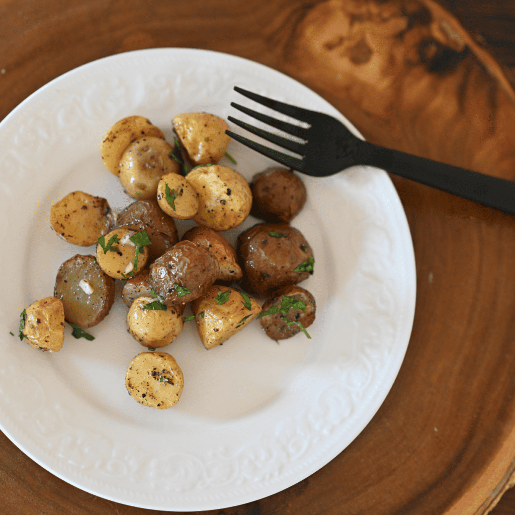 Serving Air Fryer Parmesan Potatoes with dipping sauce on the side.