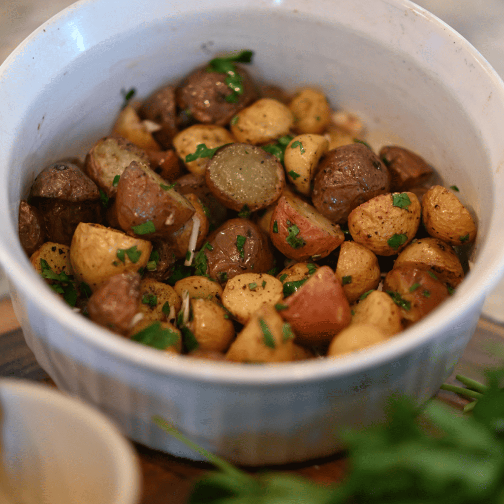Serving Air Fryer Parmesan Potatoes with dipping sauce on the side.