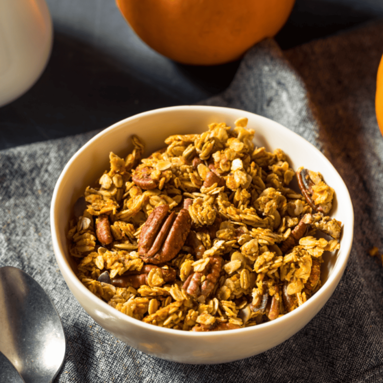 Air fryer pumpkin spice granola served in a white bowl on a wooden table