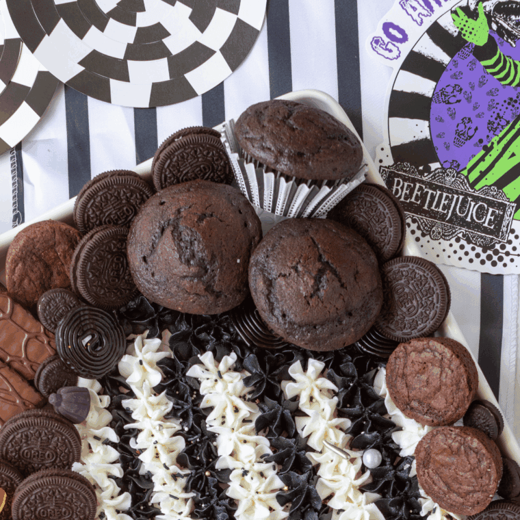 Beetlejuice-inspired buttercream board with vibrant black, white, purple, and green striped frosting.