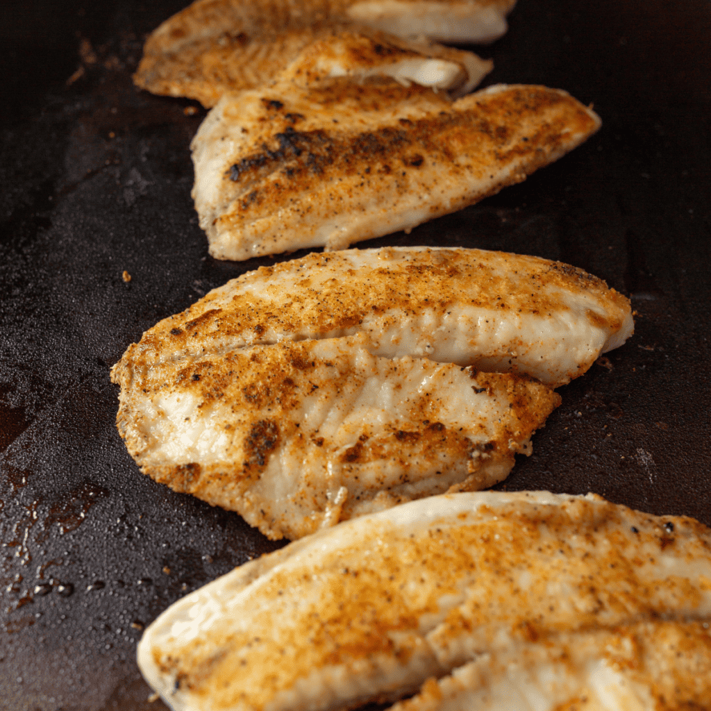 Griddle catfish served with coleslaw, hush puppies, and dirty rice
