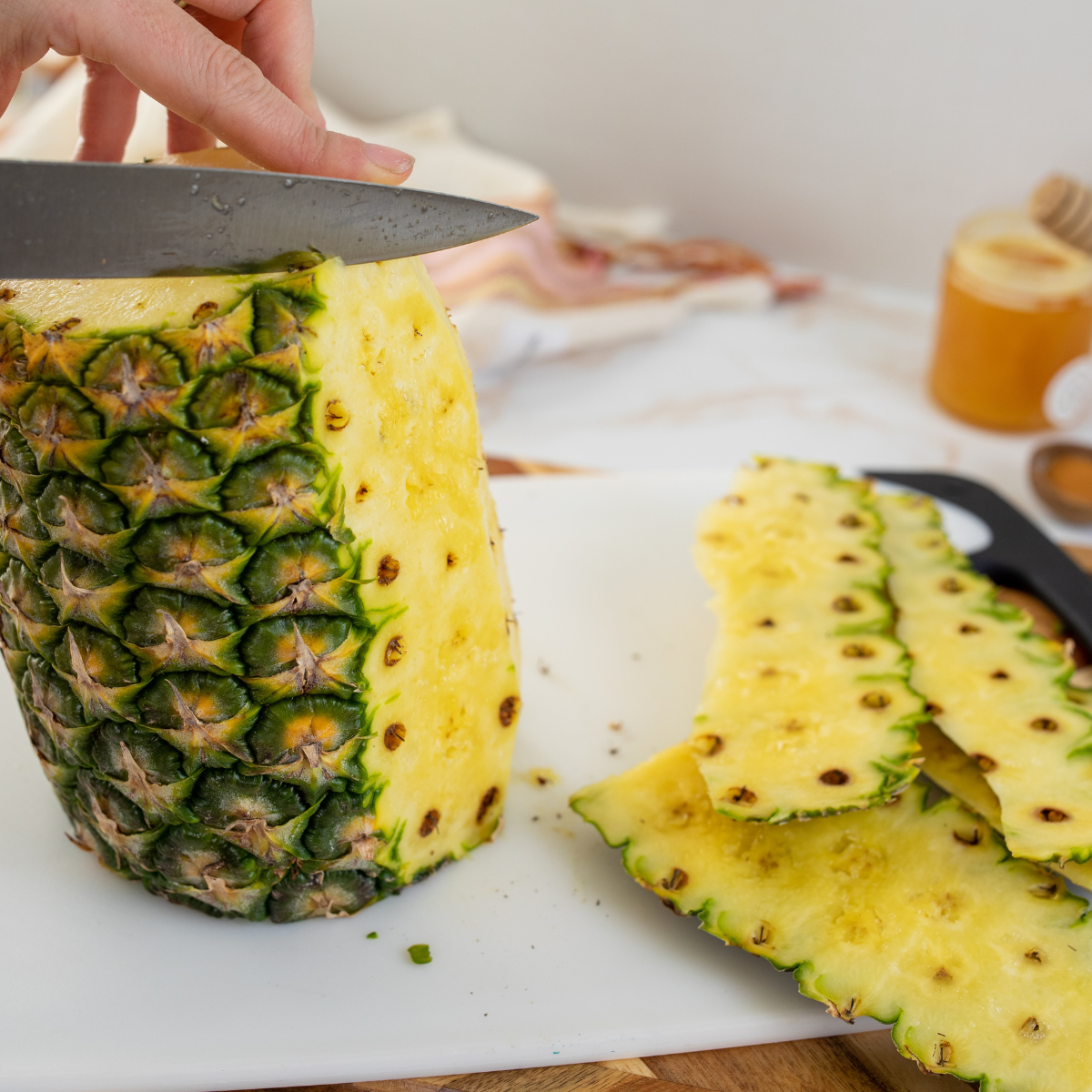 Pineapple being sliced into rounds and wedges with core optional.