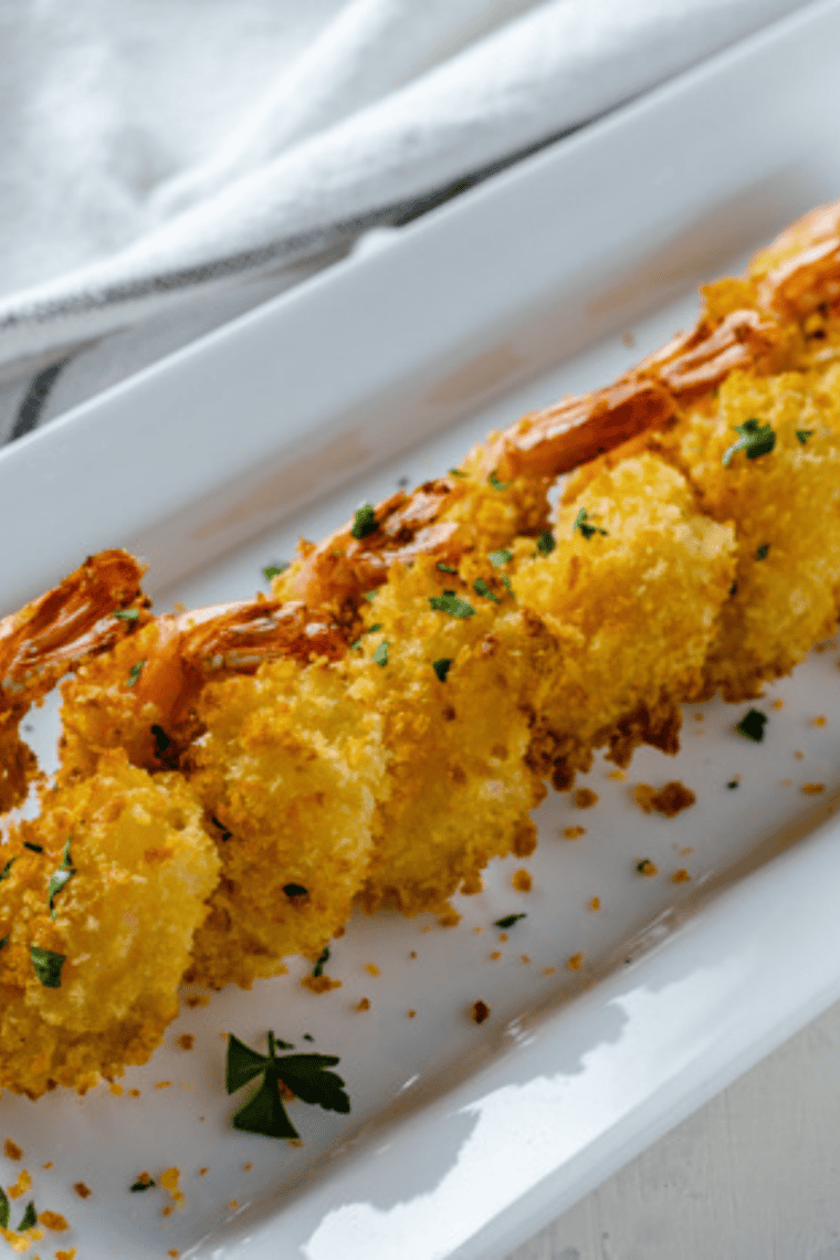 Crispy Bang Bang Shrimp coated in a creamy sweet and spicy sauce, served on a plate with fresh lettuce for a restaurant-style appetizer you can enjoy at home.