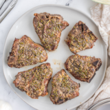 Reheated lamb chops served on a white plate