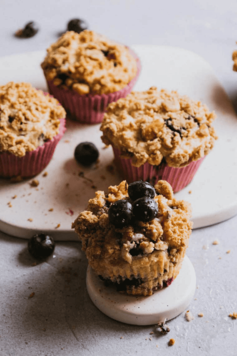 Freshly baked Ninja Woodfire Blueberry Muffins with golden tops and juicy blueberries visible inside.