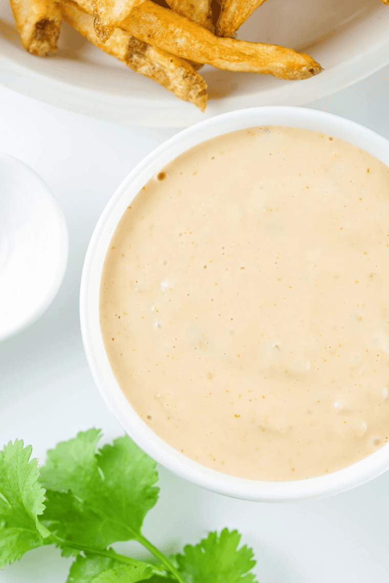 Small bowl of creamy Shake Shack copycat burger sauce with a spoon ready for serving.