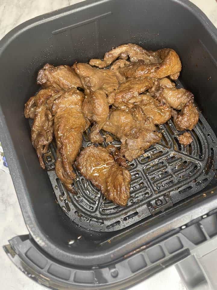 Cooked Trader Joe's Bool Kogi - A close-up image of perfectly cooked Trader Joe's Bool Kogi in an air fryer basket, showcasing the caramelized edges and vibrant color.