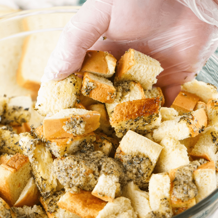 Tossing well, for the bread cubes to be coated.