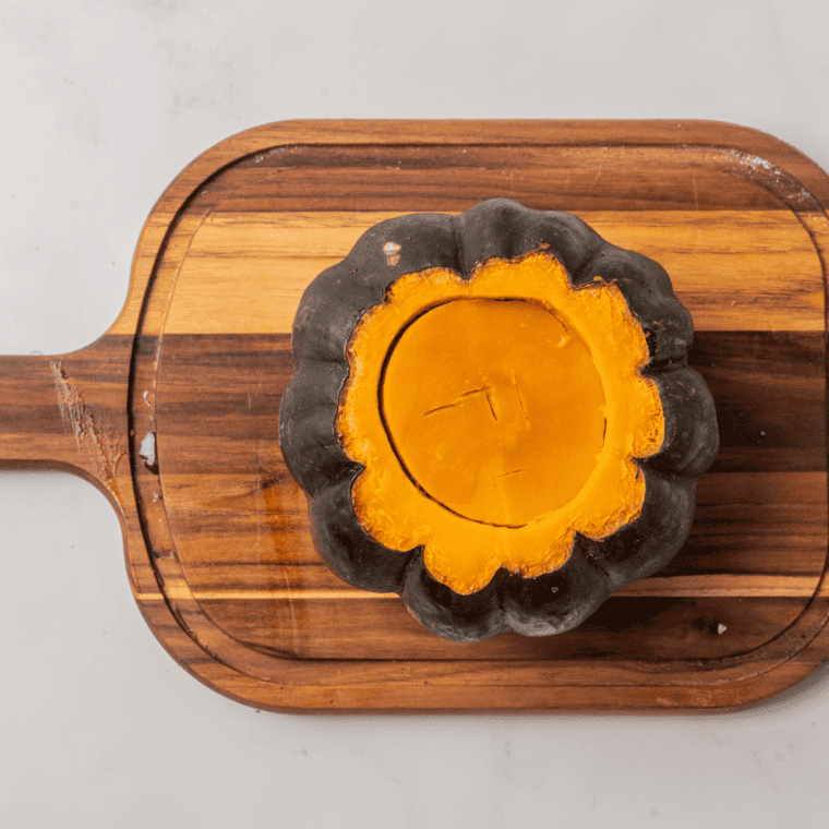 Halving the kabocha squash for air frying preparation.