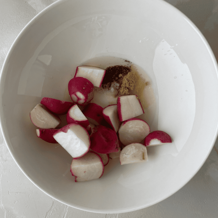 Radish pieces tossed in olive oil and seasonings ready for air frying.